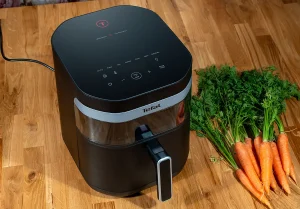 Tefal Easy Fry Infrared EY8328 - frytkownica beztłuszczowa z technologią podczerwieni na drewnianym blacie obok świeżych marchewek