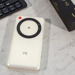 Mobilny router 5G ZTE U30 Air w białej obudowie leżący na biurku obok klawiatury i pudełka