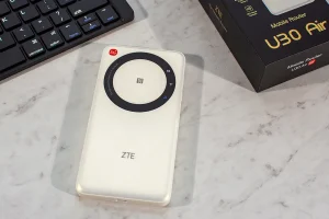 Mobilny router 5G ZTE U30 Air w białej obudowie leżący na biurku obok klawiatury i pudełka