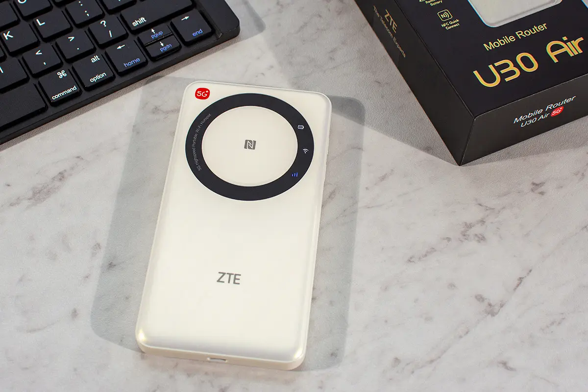 Mobilny router 5G ZTE U30 Air w białej obudowie leżący na biurku obok klawiatury i pudełka