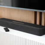 Soundbar na białej szafce pod telewizorem – zdjęcie do rankingu soundbarów TOP 10 i poradnika jaki soundbar do telewizora wybrać