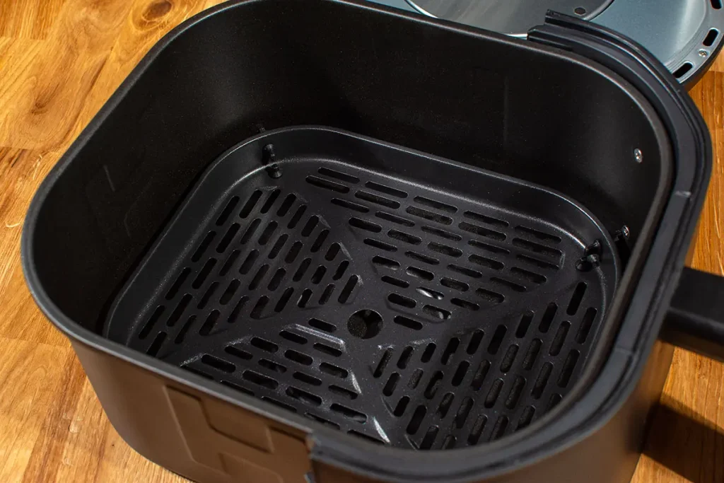 Zbliżenie na ruszt kosza Tefal Easy Fry Infrared EY8328 z powłoką nieprzywierającą i otworami zapewniającymi cyrkulację powietrza