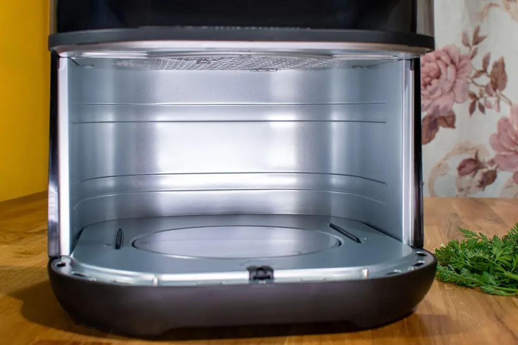 Wnętrze komory pieczenia Tefal Easy Fry Infrared EY8328 z wysuniętym koszem - widoczna stalowa komora i dolna grzałka