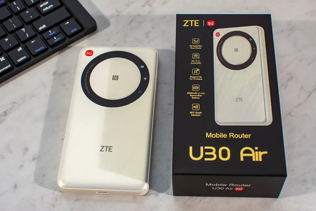 Mobilny router 5G ZTE U30 Air obok pudełka na biurku – widać oznaczenie 5G, panel NFC oraz branding ZTE
