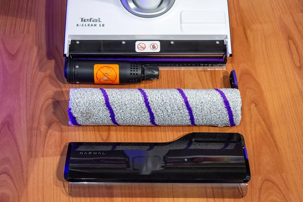 Głowica mopująca odkurzacza myjącego Tefal X-Clean 10 GF7540 z całkowicie wyjętym wałkiem - widok osłony wałka i wałka z mikrofibry leżących na drewnianej podłodze