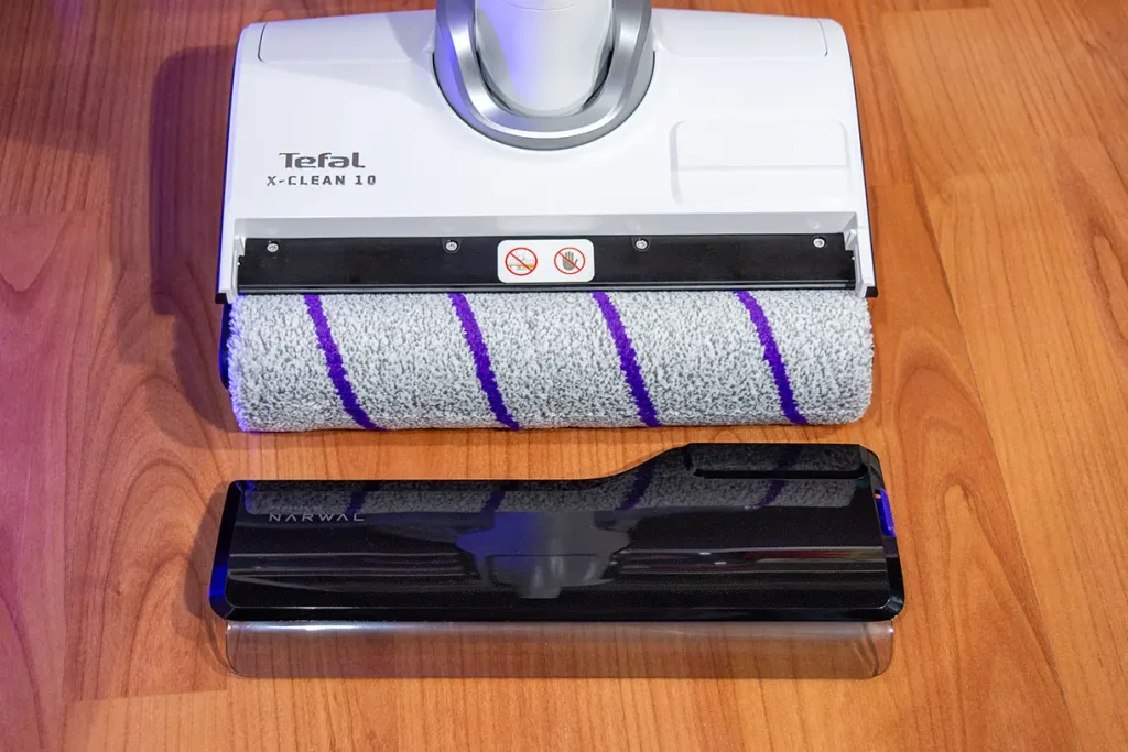 Głowica mopująca odkurzacza myjącego Tefal X-Clean 10 GF7540 z wyjętym wałkiem z mikrofibry i zdjętą osłoną wałka leżącą obok na podłodze