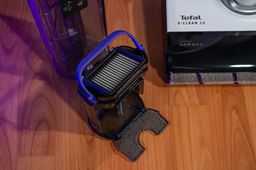 Zbiornik brudnej wody odkurzacza myjącego Tefal X-Clean 10 GF7540 z wyjętym filtrem EPA z niebieską rączką i separatorem frakcji stałej leżącym obok