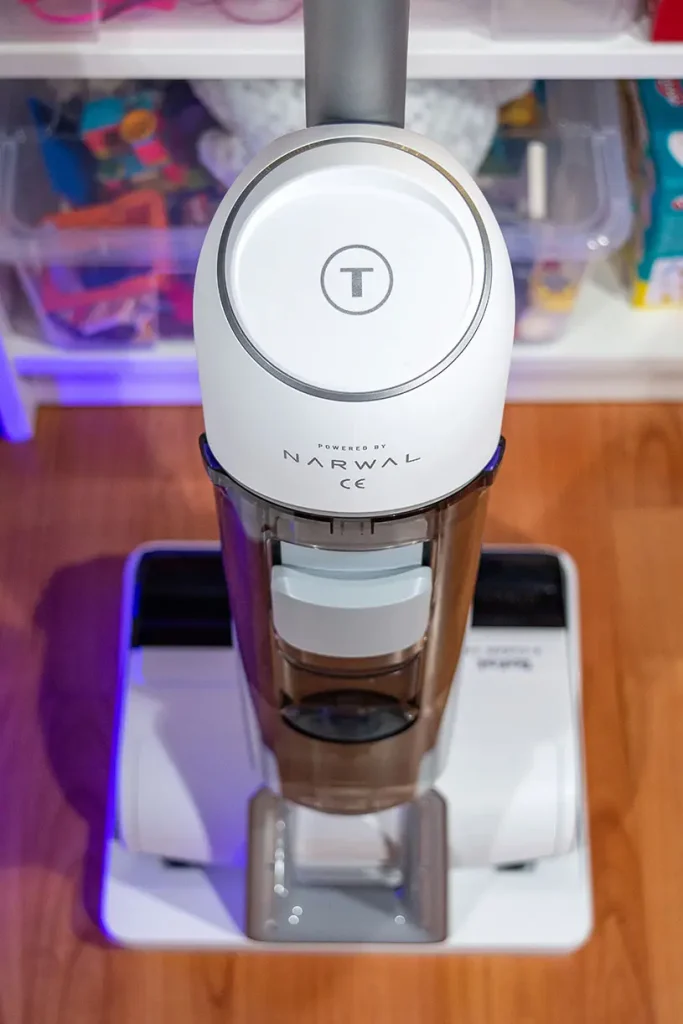 Odkurzacz myjący Tefal X-Clean 10 GF7540 w stacji dokującej - widok z przodu z widocznym przezroczystym zbiornikiem brudnej wody i oznaczeniem Powered by Narwal