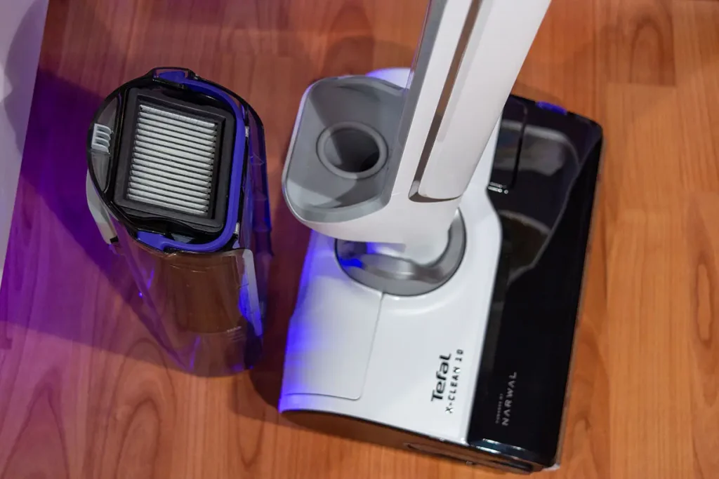 Wyjęty zbiornik brudnej wody odkurzacza myjącego Tefal X-Clean 10 GF7540 z filtrem EPA stojącym obok korpusu ustawionego obok odkurzacza