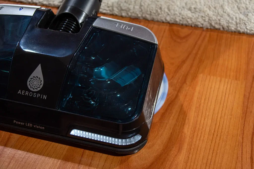Zbliżenie na głowicę AeroSpin Aqua odkurzacza Tefal X-Force Flex 16.60 na parkiecie – transparentny zbiornik na wodę i diody LED Power LED vision